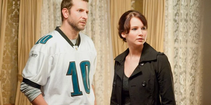 Jennifer Lawrence and Bradley Cooper wearing a NFL jersey in Silver Linings Playbook 10 filmes da Netflix que destacam a saúde mental