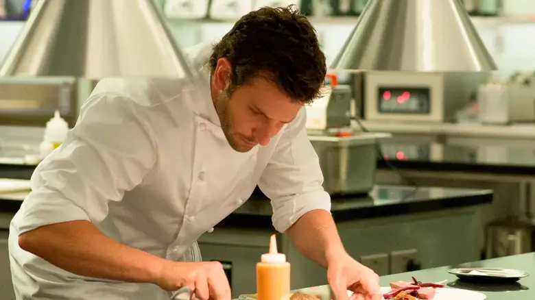 Adam plating a dish in Burnt