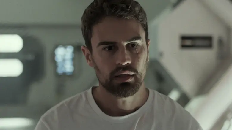 Theo James's George Almore stands looking worried in his lab in Archive