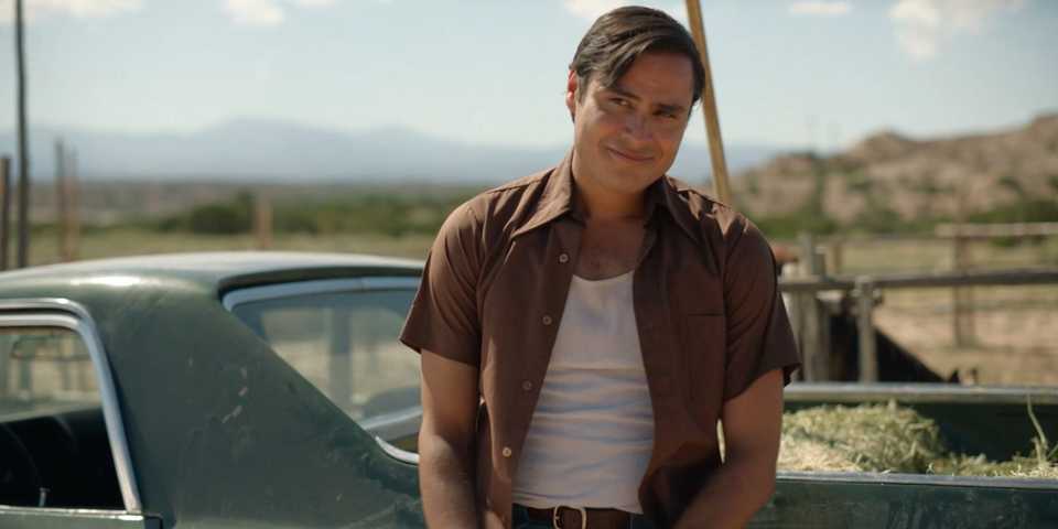 Dark Winds: Surpresas na Quarta Temporada 20 Jim Chee (Kiowa Gordon) smiling while leaning against a truck in Dark Winds season 3, episode 8