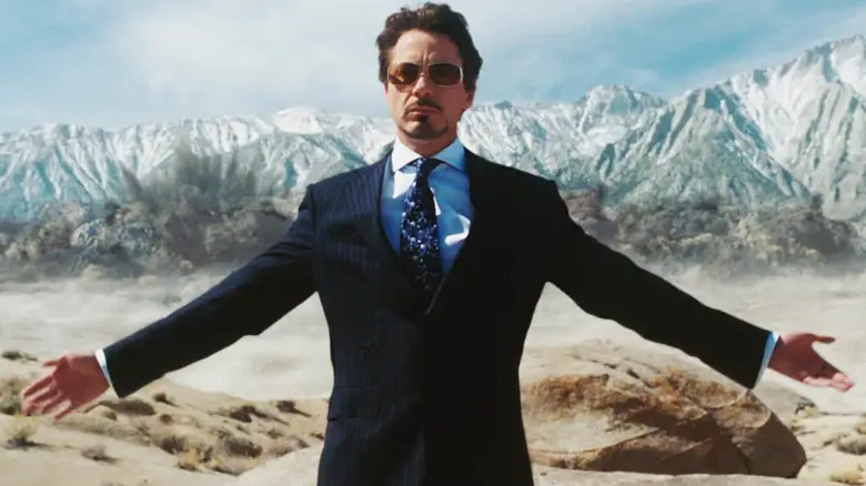 Robert Downey Jr's Tony Stark stands with his arms spread in the desert in Iron Man