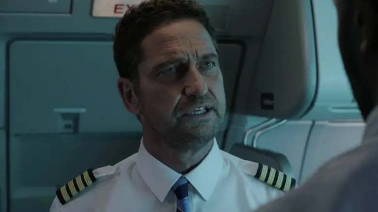 Gerard Butler as Brodie on a plane looking up at Louis in Plane