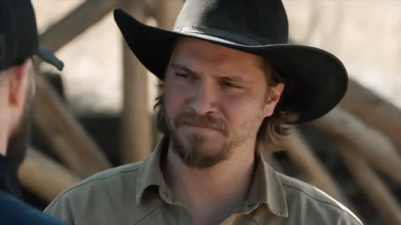 Luke Grimes as Kayce Dutton wearing a cowboy hat and looking concerned on Marshals