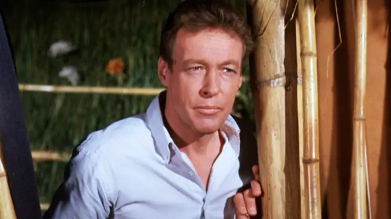 Russell Johnson's Professor Roy Hinkley stands next to some bamboo in Gilligan's Island