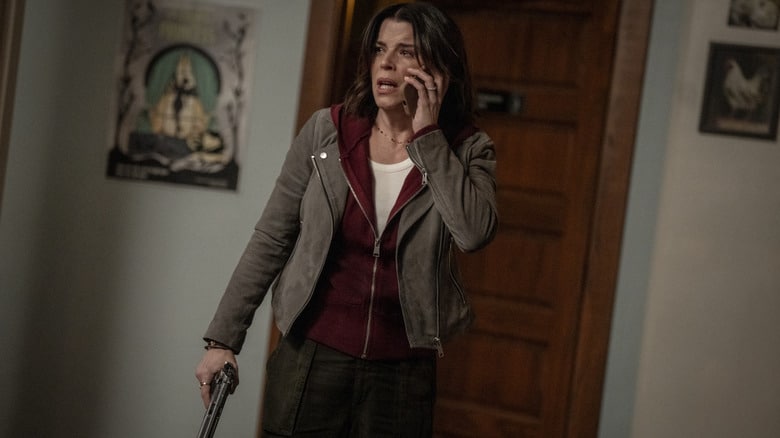 Neve Campbell as Sidney Evans looking scared while on the phone and holding a gun inside a house in Scream 7