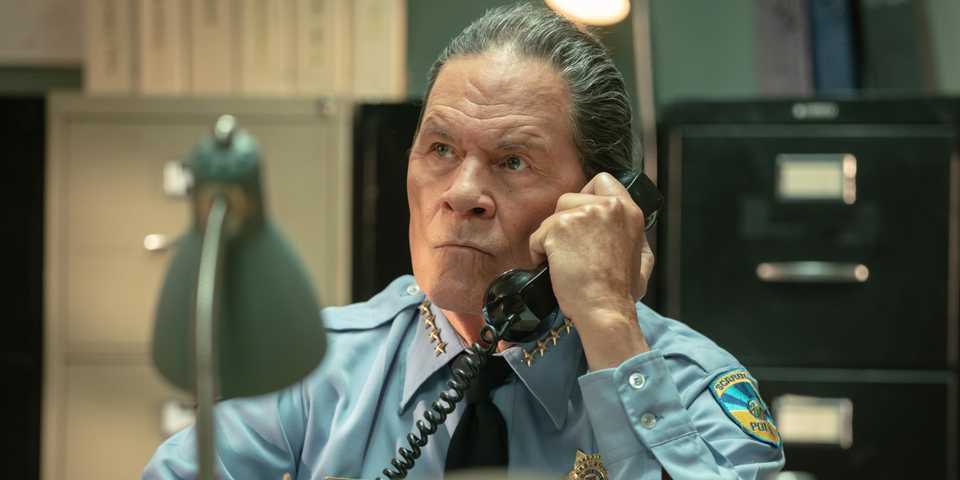 Dark Winds: Surpresas na Quarta Temporada 15 A character on the phone as they clench their jaw in Dark Winds