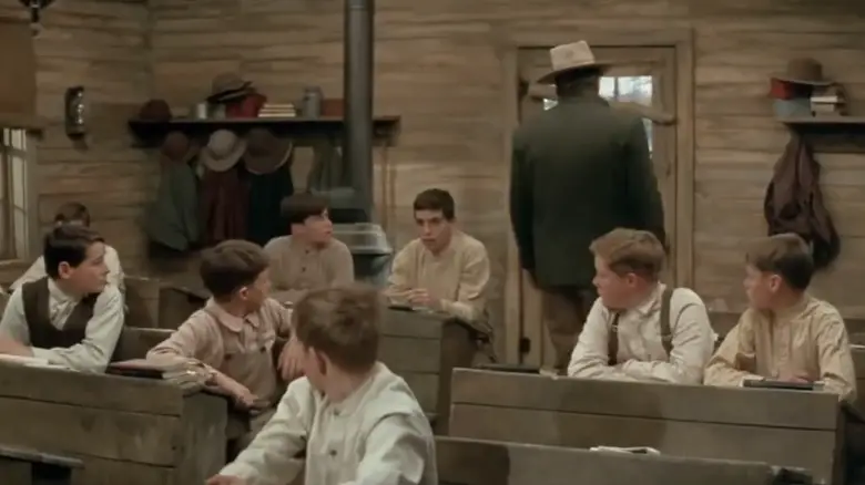 The schoolboys all turn to watch John Wayne's Wil Andersen walk out of their classroom in The Cowboys