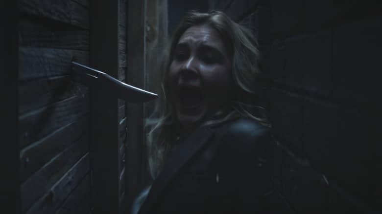 Isabel May as Tatum Evans sneaking through a crawlspace and screaming as a knife plunges through a wall in Scream 7