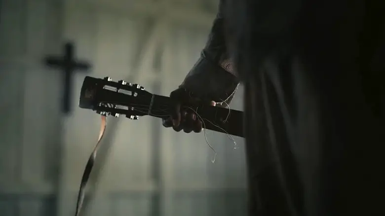 Sammie holding his broken guitar in Sinners