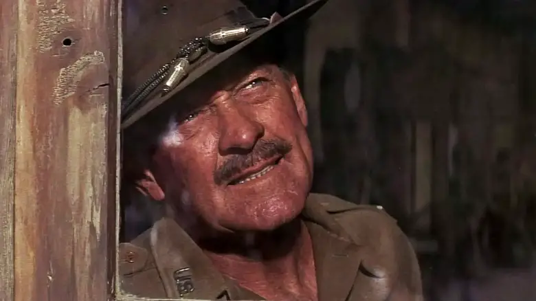 William Holden's Pike Bishop looks out of a house in closeup in The Wild Bunch