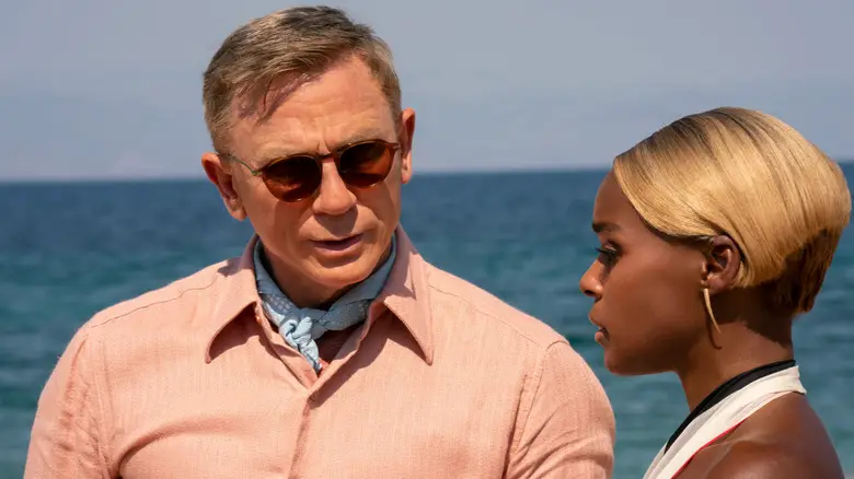 Benoit Blanc (Daniel Craig) speaks with Helen Brand (Janelle Monáe) by the ocean in Glass Onion: A Knives Out Mystery