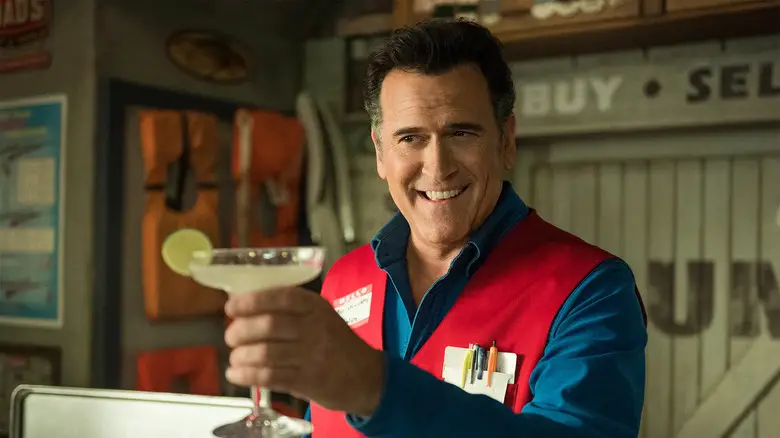 Bruce Campbell as Ash Williams in Ash vs the Evil Dead holding up a cocktail