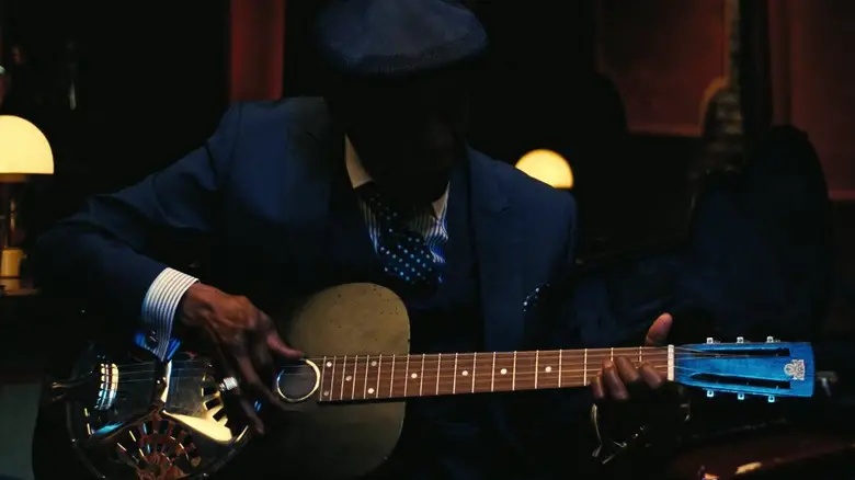 Old Sammie playing the guitar in Sinners