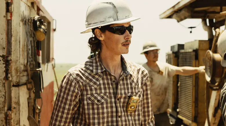 Jacob Lofland's Cooper Norris stands by an oil rig wearing a hardhat in Landman
