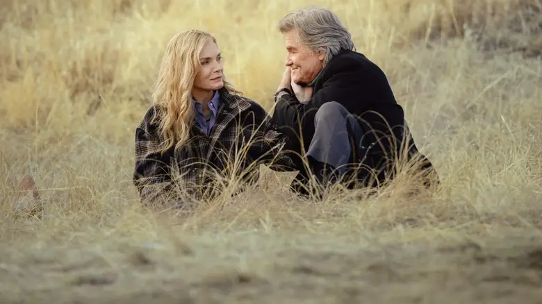 Stacy (Michelle Pfeiffer) and Preston (Kurt Russell) sitting in the grass on "The Madison"