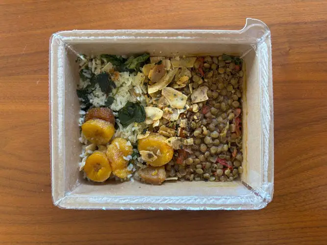 Mosaic Foods Jerk Lentil and Plantain Bowl on a wood table.