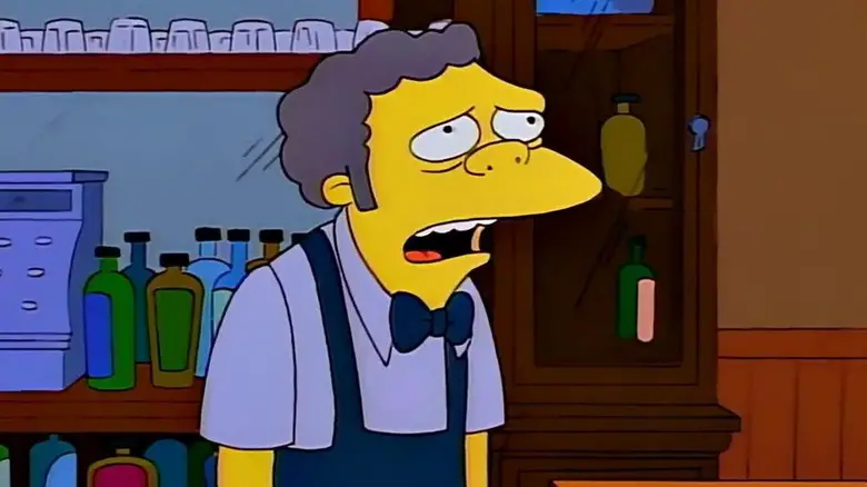Moe Szyslak standing behind the bar at Moe's in The Simpsons