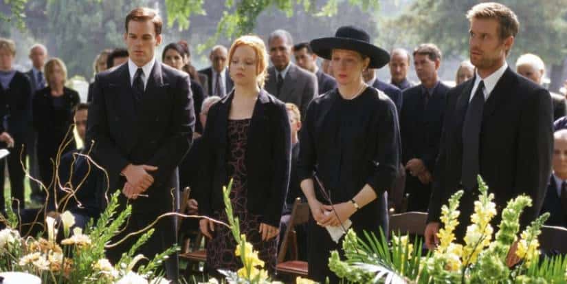 Image from Six Feet Under's pilot released in 2001 of people standing at a graveside service.