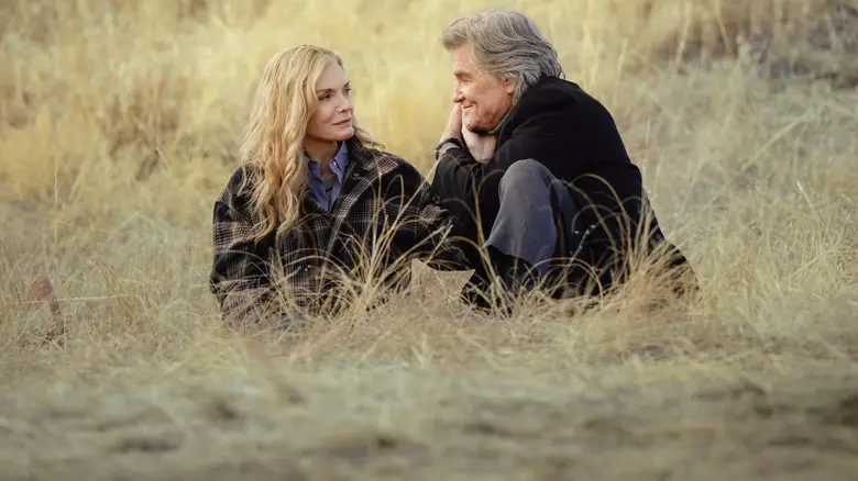 Stacy (Michelle Pfeiffer) and Preston (Kurt Russell) sitting in the grass on "The Madison"