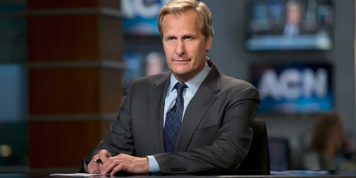 Jeff Daniels as Will McAvoy sitting at the anchor desk in The Newsroom