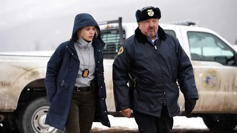 Jane Banner (Elizabeth Olsen) and Ben Shoyo (Graham Greene) walk by a pickup truck in Wind River
