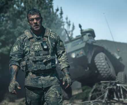 Preços da Netflix Sobem Novamente: Impacto nos Assinantes 39 81 (Alan Ritchson), an Army sergeant in grimy fatigues, covered with mud and blood, stands in front of a wrecked army vehicle in War Machine