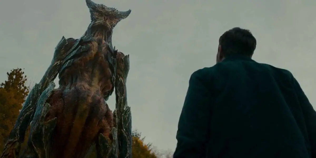 A man looking up at a monster in Colossal