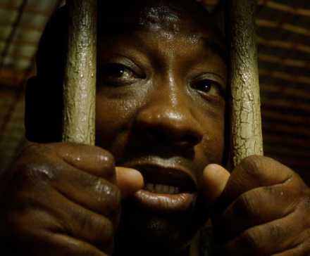 Michael Clarke Duncan as John Coffey holding prison bars in The Green Mile